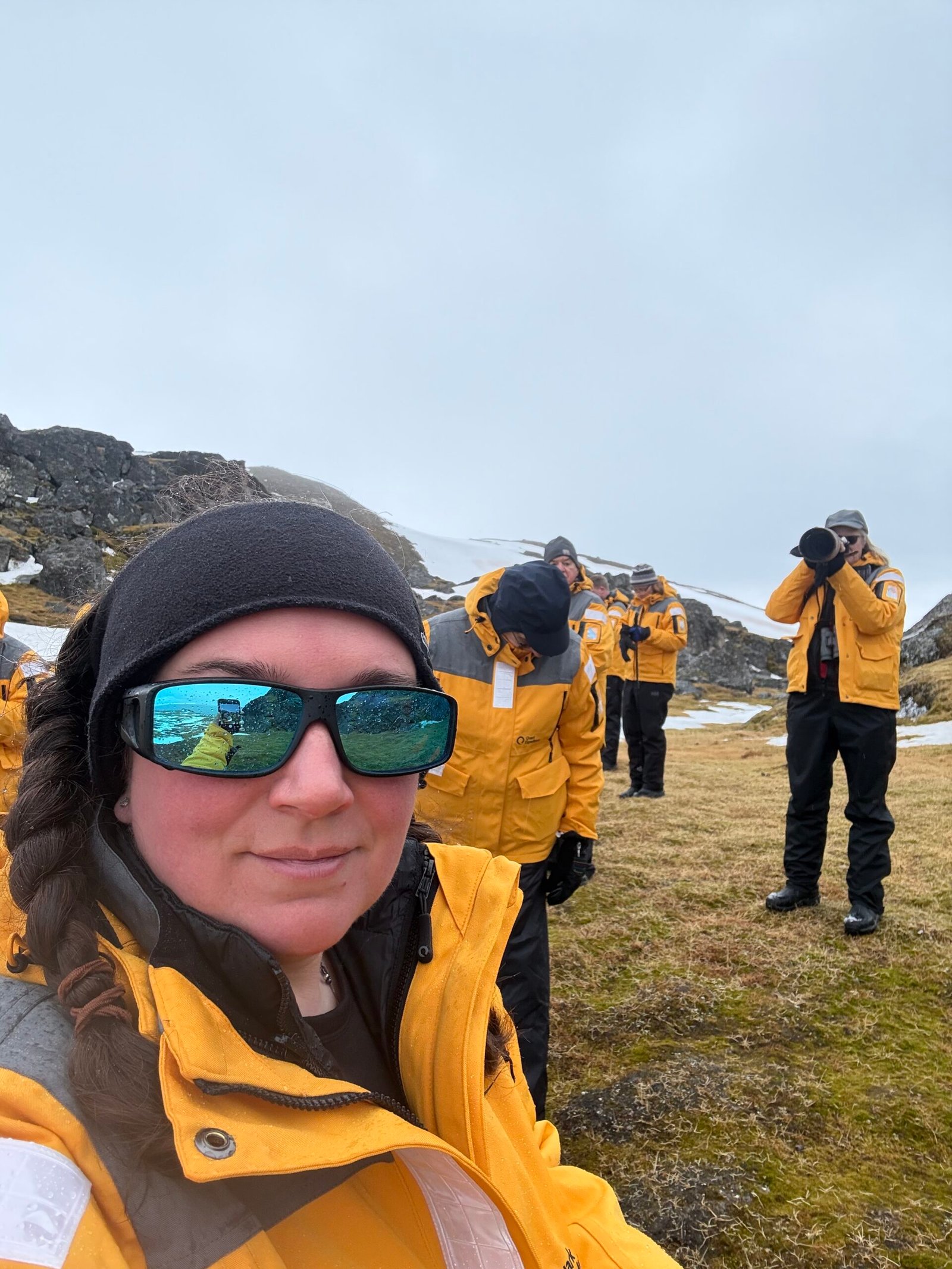 Amanda Cahill in a yellow expedition jacket during a shore landing in Svalbard