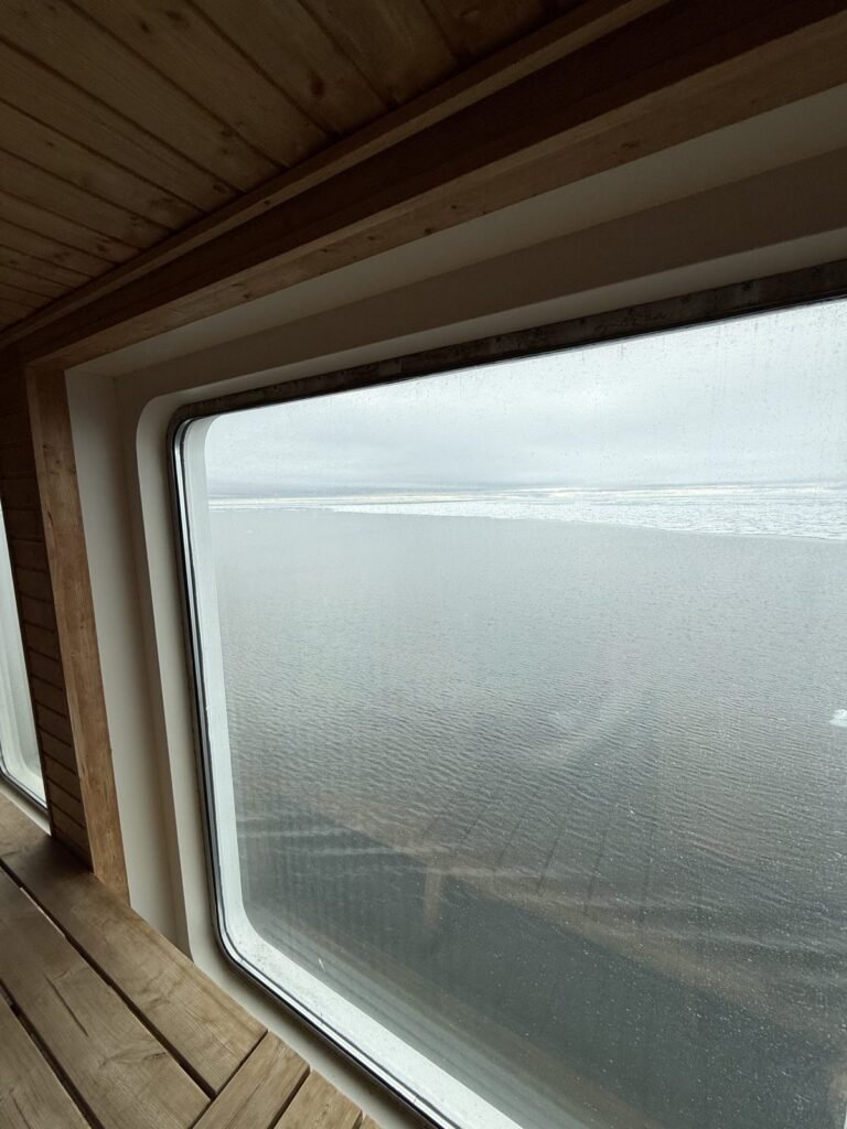 View of Arctic sea ice through the window of an expedition ship sauna