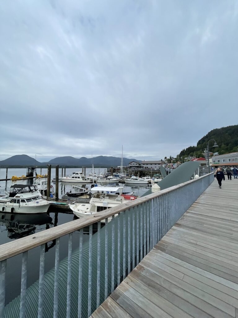 Ketchikan's waterfront boardwalk beside the marina, with houses on the forested hillside behind