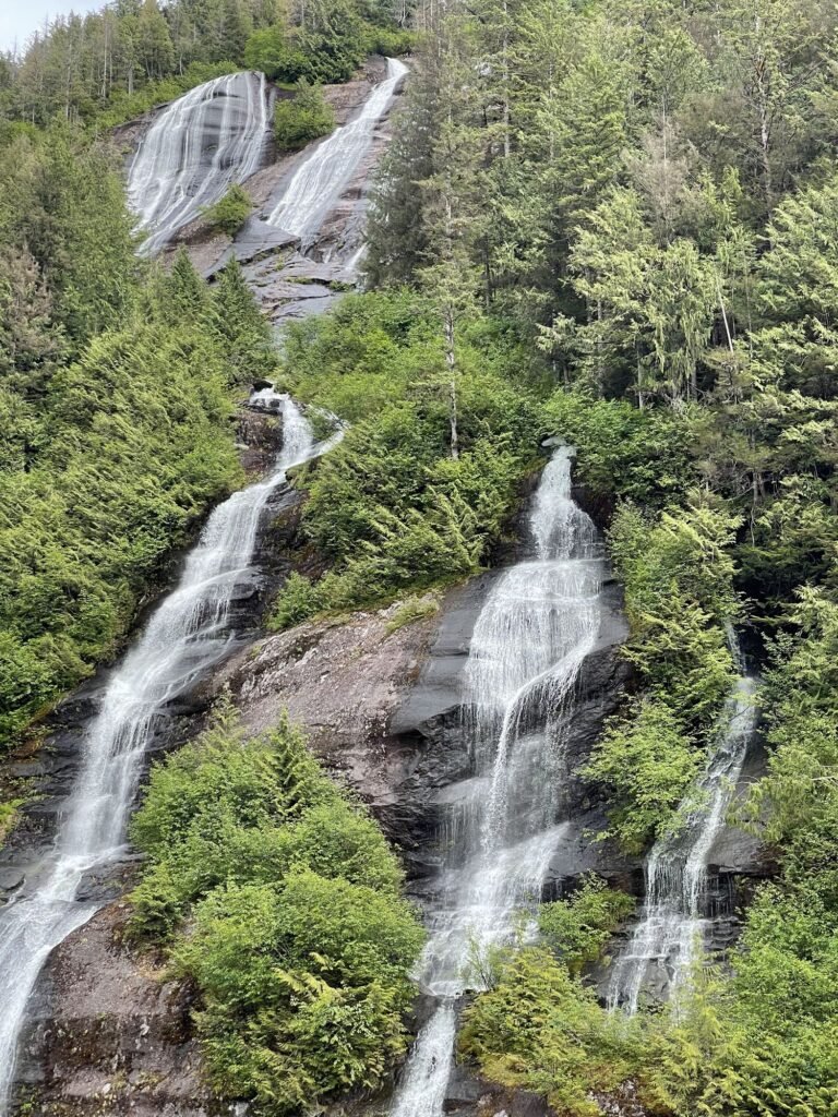 Three Sisters waterfall pouring down granite cliffs in Misty Fjords National Monument, Alaska